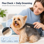 Black electric flea comb for pets brushing a small dog's back during home grooming.