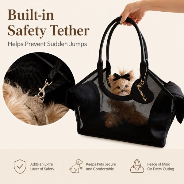 Black mesh pet carrier tote showing the interior tether clipped near the dog's harness.