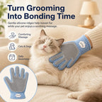 Blue dual sided pet grooming glove massaging a resting cat's cheek during grooming.
