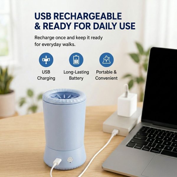 Electric pet paw cleaner in blue connected to a USB charging cable beside a laptop.