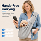 Gray crossbody pet sling carrier worn while holding a phone with a small dog in the pouch.