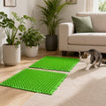 Green cat deterrent mat with two panels on the floor near a sofa and cat.