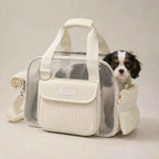 Mesh pet carrier tote in cream with a small dog looking out of the side opening.