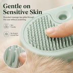 Pet spray grooming brush closeup of rounded grooming pins beneath a fingertip.