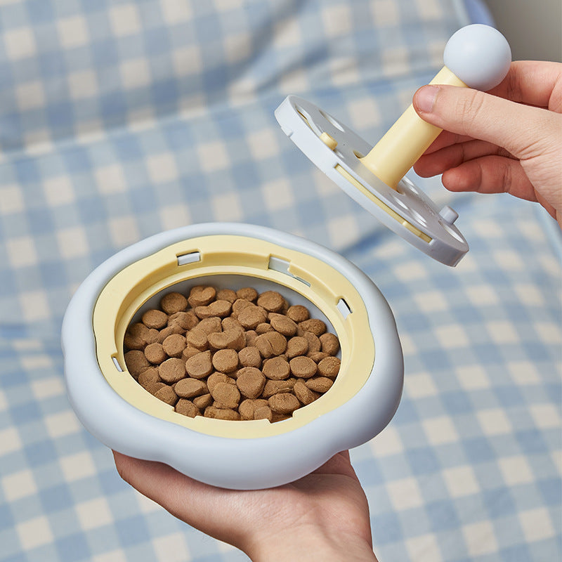 Dry food being added to the rotating pet puzzle feeder