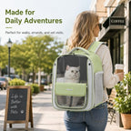 Transparent cat backpack carrier in green worn on a city outing with a cat inside.